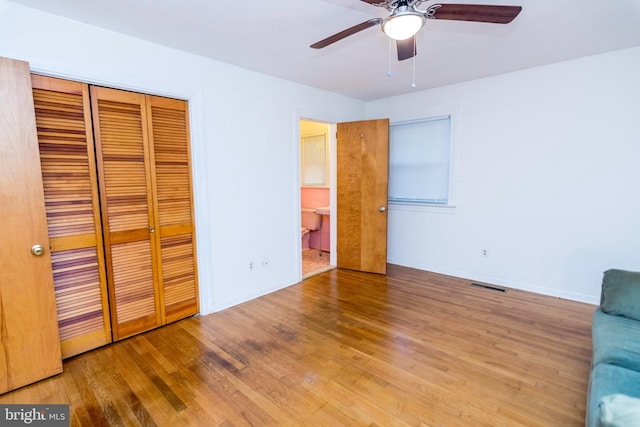 unfurnished bedroom with a closet, light wood-type flooring, and ceiling fan