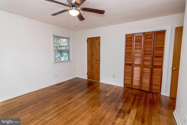 unfurnished bedroom featuring dark wood-type flooring and ceiling fan