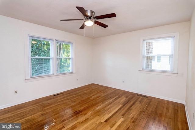 spare room with hardwood / wood-style floors, a healthy amount of sunlight, and ceiling fan