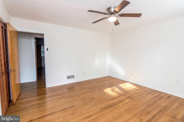 empty room featuring visible vents, baseboards, wood finished floors, and ceiling fan
