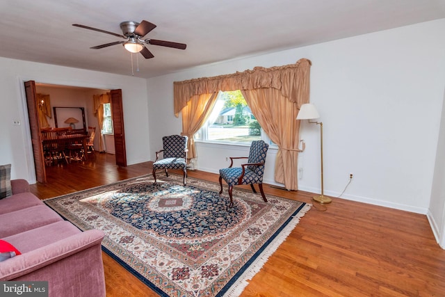 sitting room featuring wood-type flooring and ceiling fan