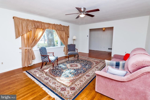 living area featuring hardwood / wood-style floors and ceiling fan