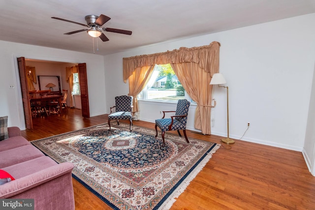 sitting room with light wood-type flooring, baseboards, and ceiling fan