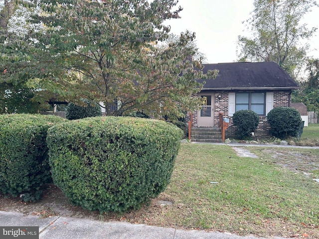 view of front of home featuring brick siding and a front yard