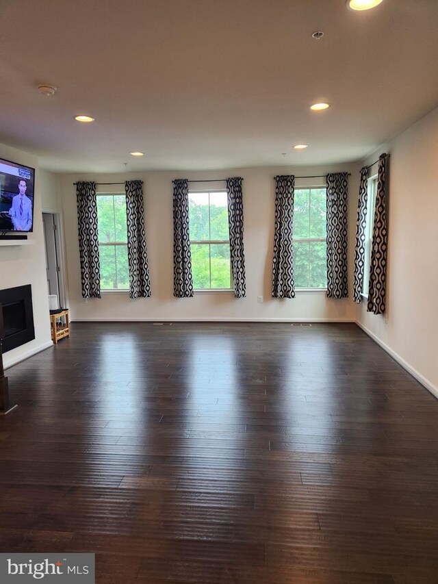 unfurnished living room featuring dark wood-type flooring