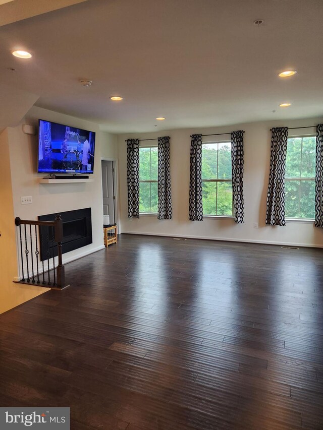 unfurnished living room featuring dark wood-type flooring