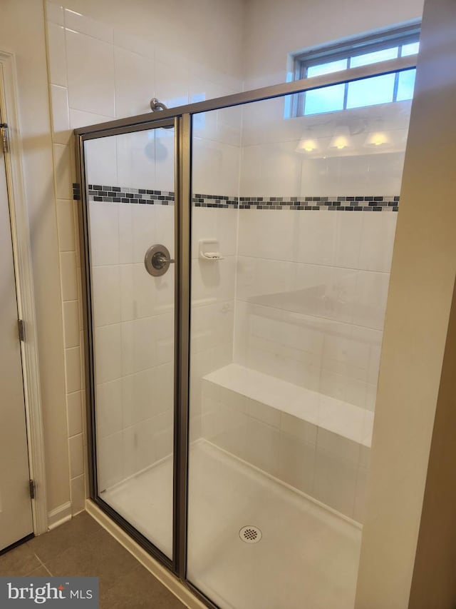 bathroom with tile patterned flooring and a shower with shower door