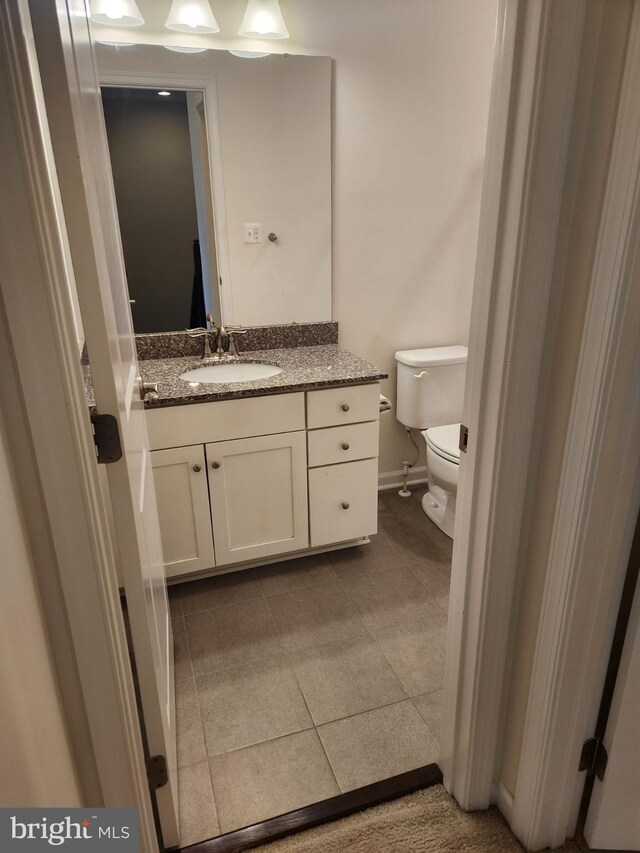 bathroom featuring vanity, tile patterned flooring, and toilet