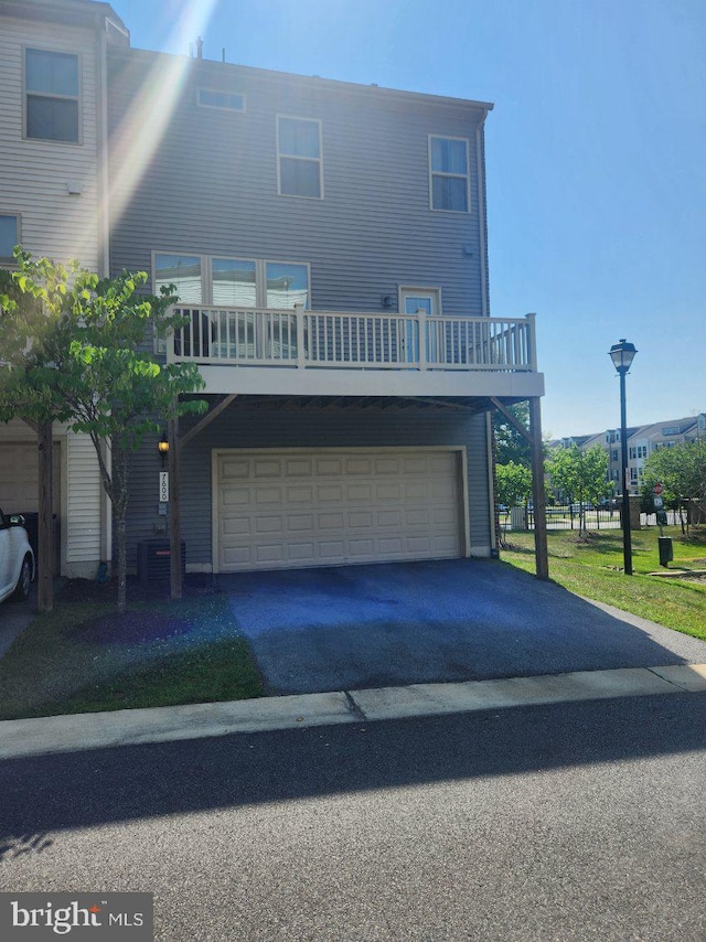 view of front of property with a mountain view, central AC unit, and a garage