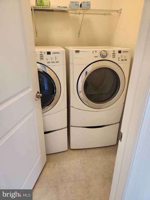 laundry area featuring washer and clothes dryer and light tile patterned floors