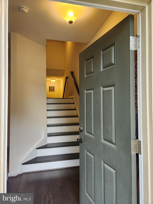 stairs featuring hardwood / wood-style floors