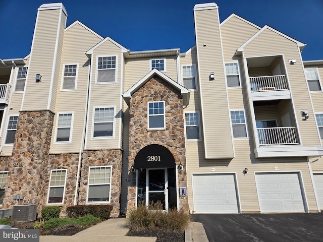 view of front of property featuring cooling unit and a balcony