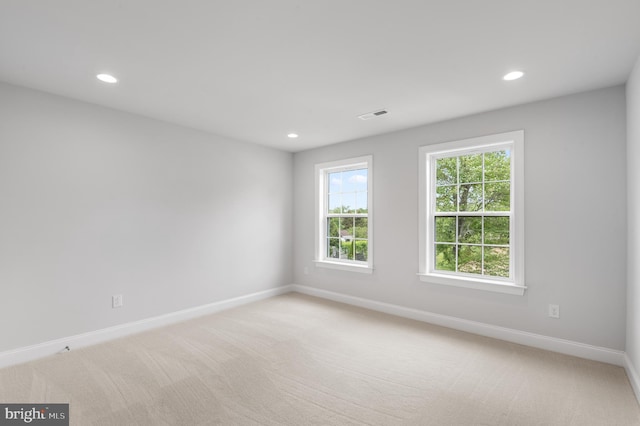 empty room featuring light carpet, baseboards, visible vents, and recessed lighting