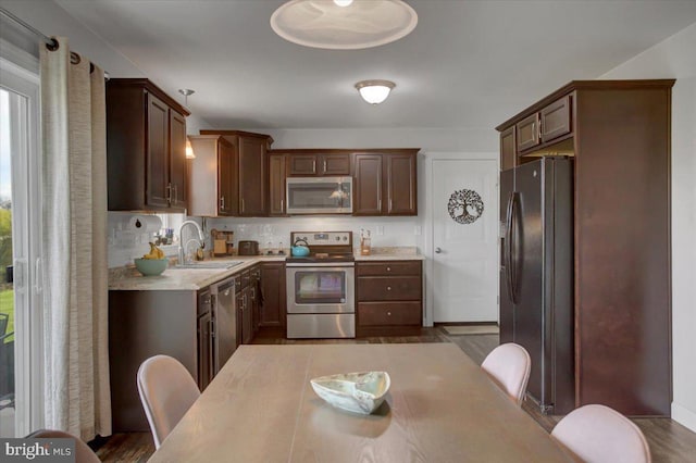 kitchen featuring wood-type flooring, appliances with stainless steel finishes, sink, and a healthy amount of sunlight