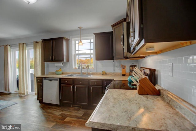 kitchen featuring dark brown cabinetry, dark wood-type flooring, sink, hanging light fixtures, and appliances with stainless steel finishes