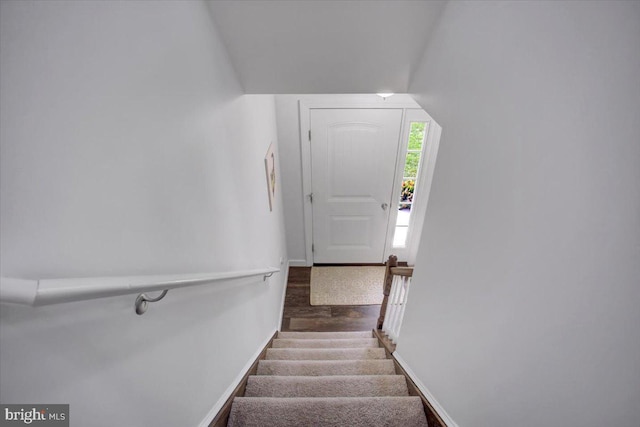 staircase featuring vaulted ceiling and wood-type flooring