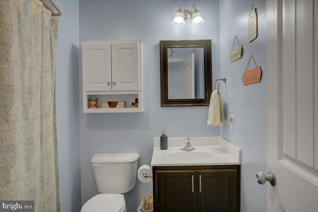 bathroom featuring vanity, toilet, and curtained shower