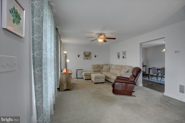 carpeted living room with ceiling fan