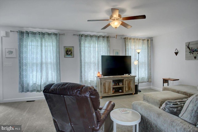 carpeted living room with ceiling fan