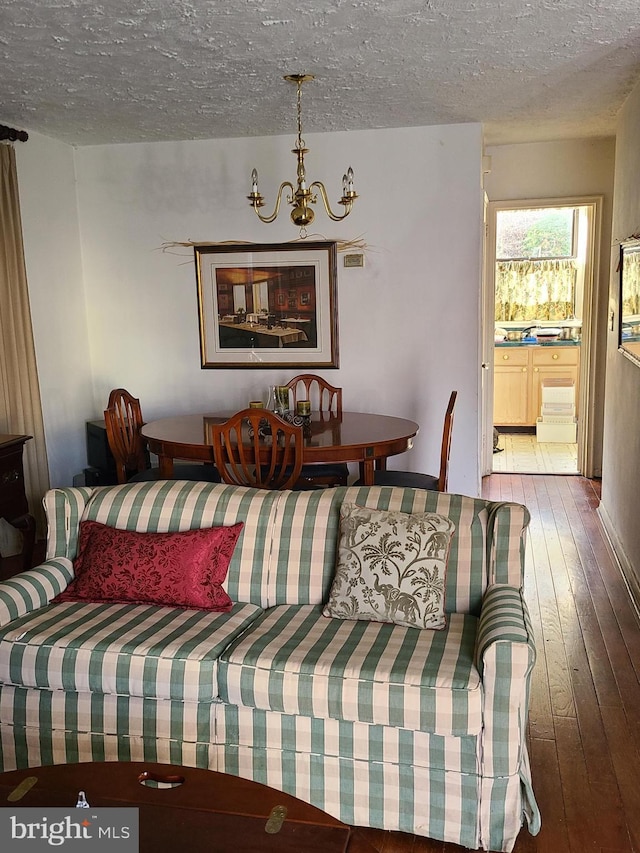 living room featuring hardwood / wood-style floors, a notable chandelier, and a textured ceiling