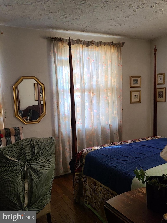 bedroom featuring hardwood / wood-style floors and a textured ceiling