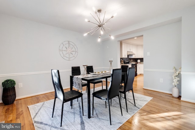 dining area featuring light hardwood / wood-style flooring and an inviting chandelier