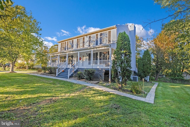 view of front of property featuring a front lawn, central AC unit, and a porch