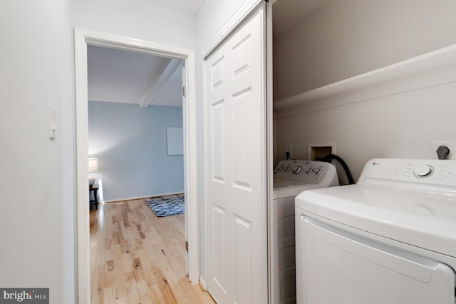 laundry room with washer and clothes dryer and light wood-type flooring