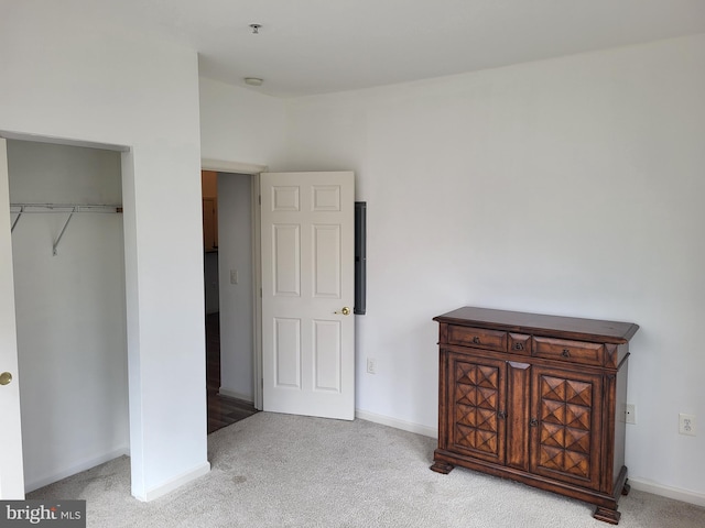 bedroom with a closet and light colored carpet