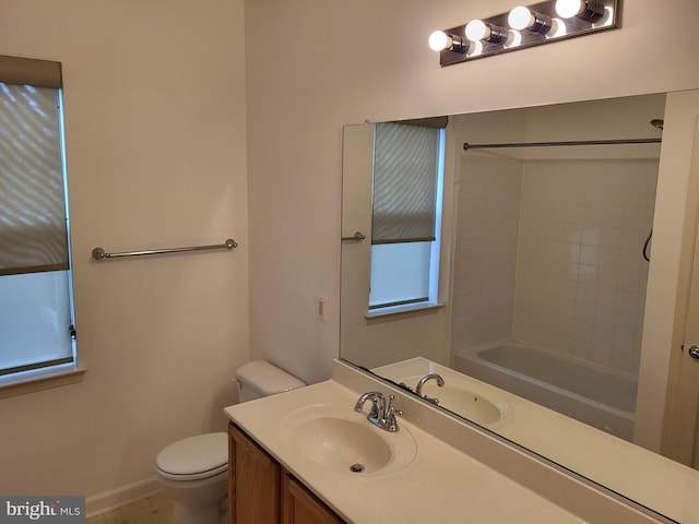 full bathroom featuring tiled shower / bath, vanity, and toilet