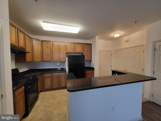 kitchen featuring light wood-type flooring, black appliances, and a kitchen island