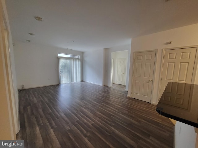 unfurnished living room featuring dark wood-type flooring