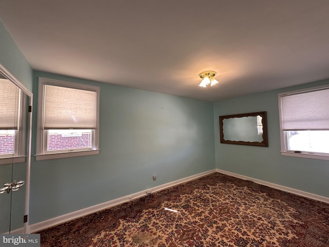 carpeted spare room featuring plenty of natural light