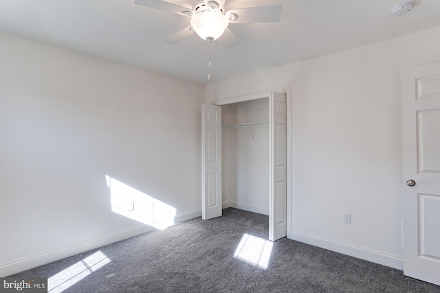 unfurnished bedroom featuring a closet, dark carpet, and ceiling fan