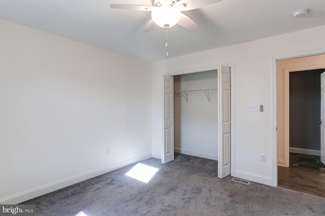 unfurnished bedroom with ceiling fan, dark carpet, and a closet