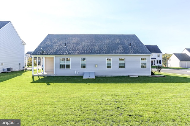 rear view of property featuring a yard and central AC