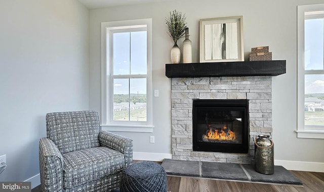 living area with hardwood / wood-style floors, a healthy amount of sunlight, and a fireplace