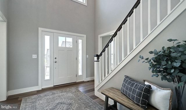 foyer entrance with a high ceiling and dark hardwood / wood-style floors