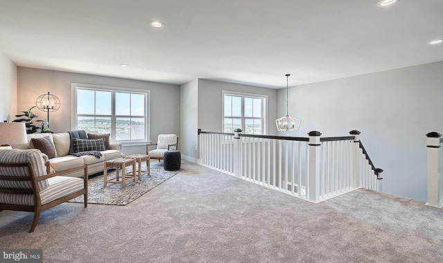 living room featuring carpet and an inviting chandelier