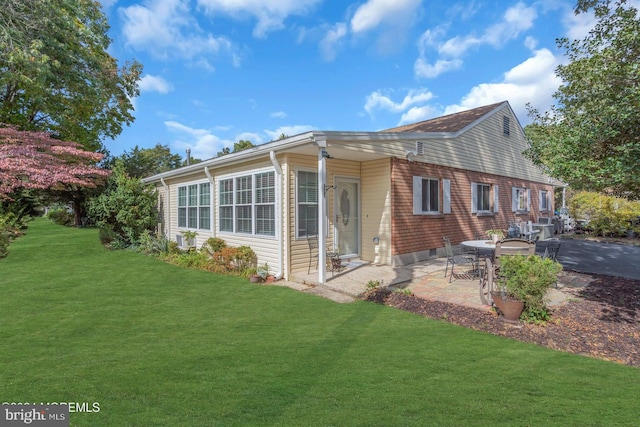 view of front of house featuring a front lawn and a patio