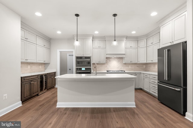 kitchen with a center island with sink, white cabinetry, stainless steel appliances, and dark hardwood / wood-style flooring