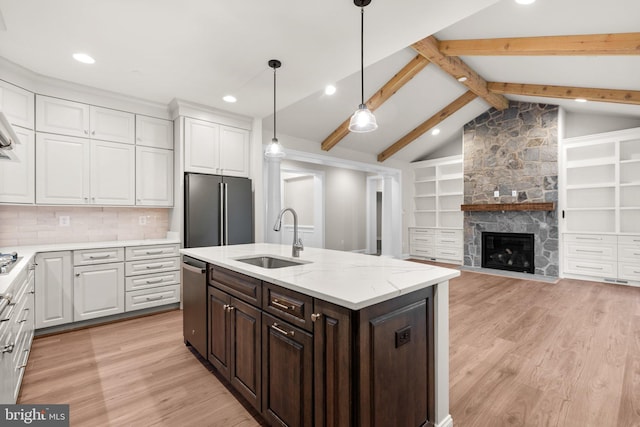 kitchen featuring sink, white cabinets, stainless steel appliances, and lofted ceiling with beams