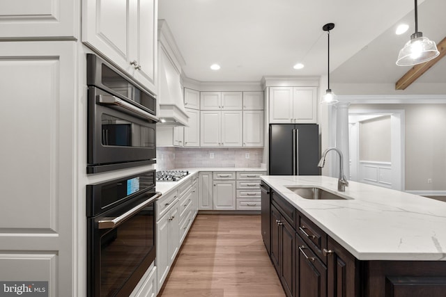 kitchen with sink, white cabinets, light stone counters, and stainless steel appliances