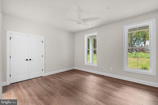 unfurnished bedroom with a closet, light wood-type flooring, and ceiling fan