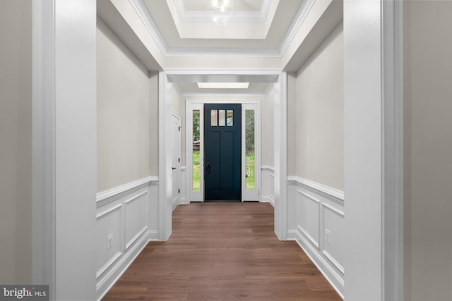 doorway to outside featuring a raised ceiling, ornamental molding, and hardwood / wood-style floors