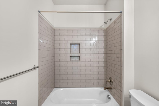 bathroom featuring toilet and tiled shower / bath combo