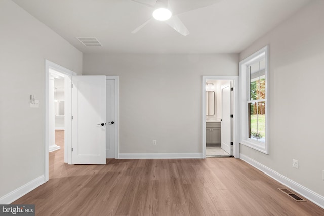 unfurnished bedroom with light hardwood / wood-style flooring, ceiling fan, and ensuite bath