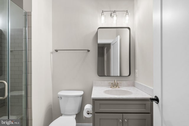 bathroom with vanity, toilet, and a shower with shower door