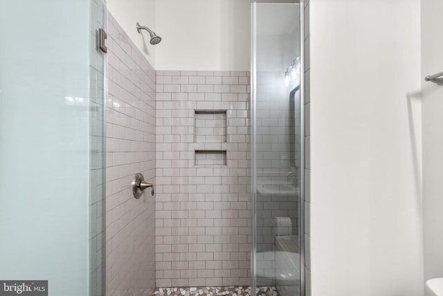 bathroom with toilet and a shower with shower door