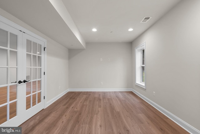 empty room with french doors and light wood-type flooring